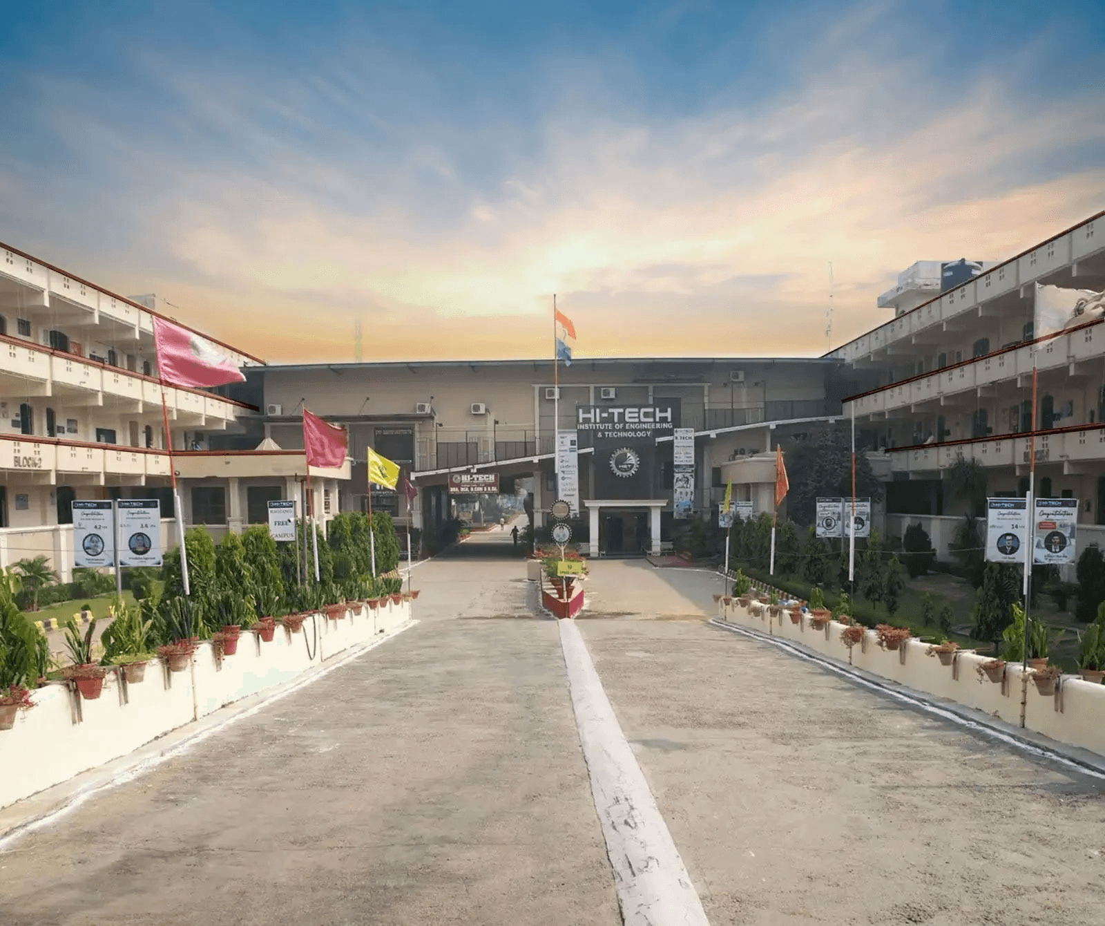 Hi-Tech Institute of Engineering and Technology campus entrance with flags at sunset